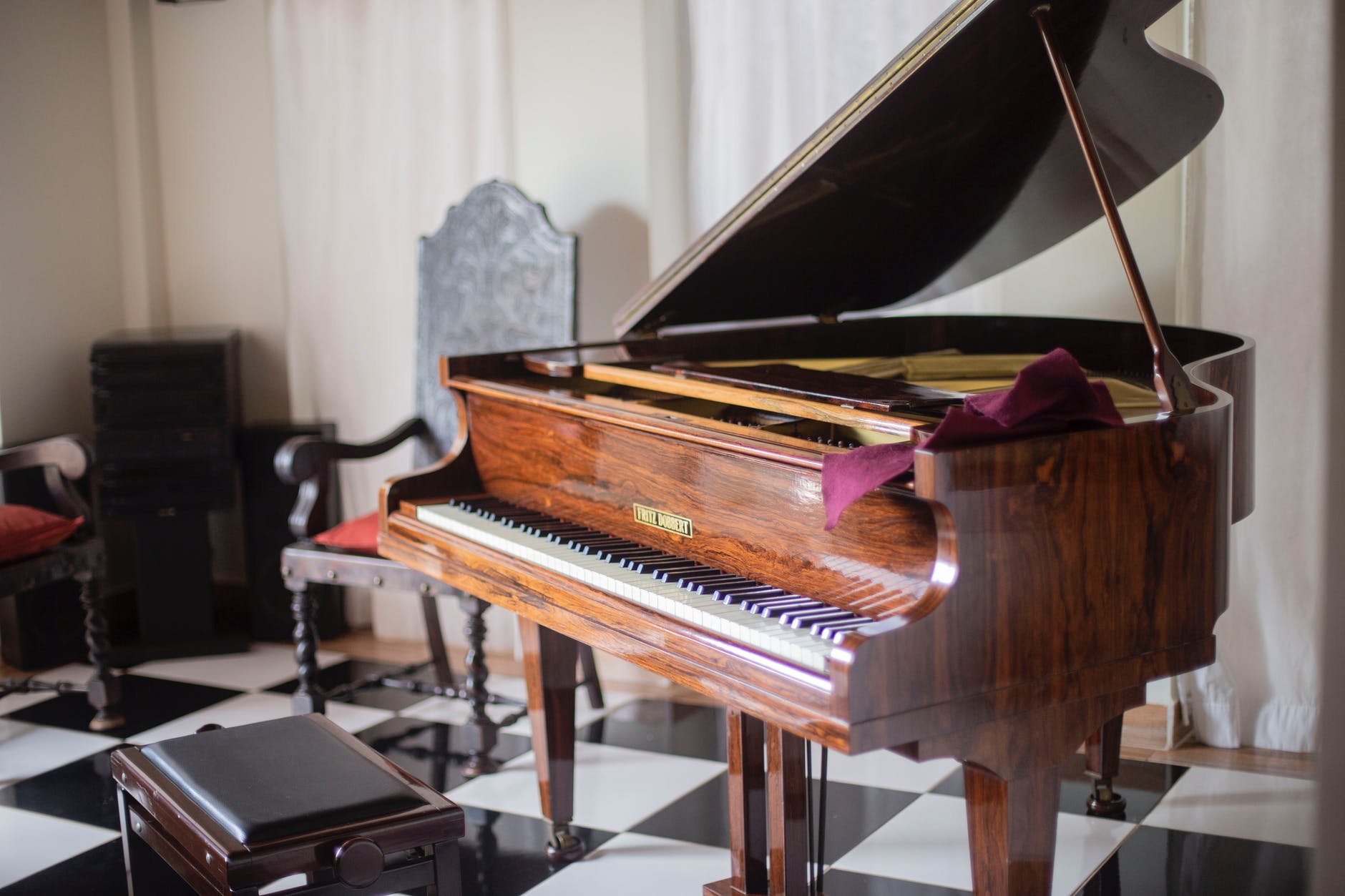 brown grand piano with chair